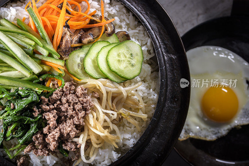 BI Bim Bap，拌菜饭，顶视图与热酱在铸铁锅